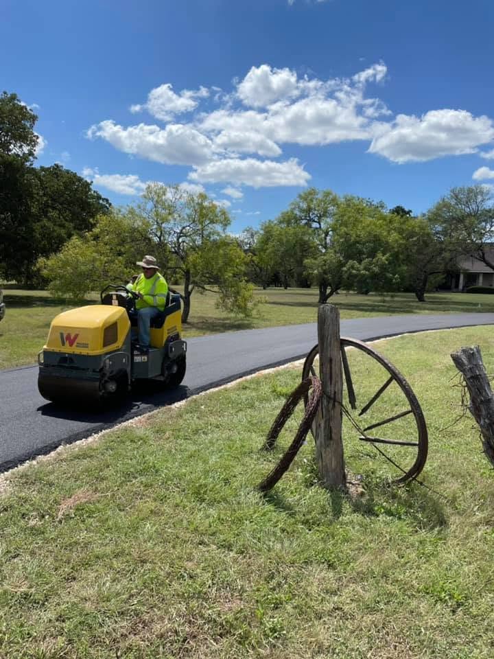 Road roller compacts a newly paved driveway