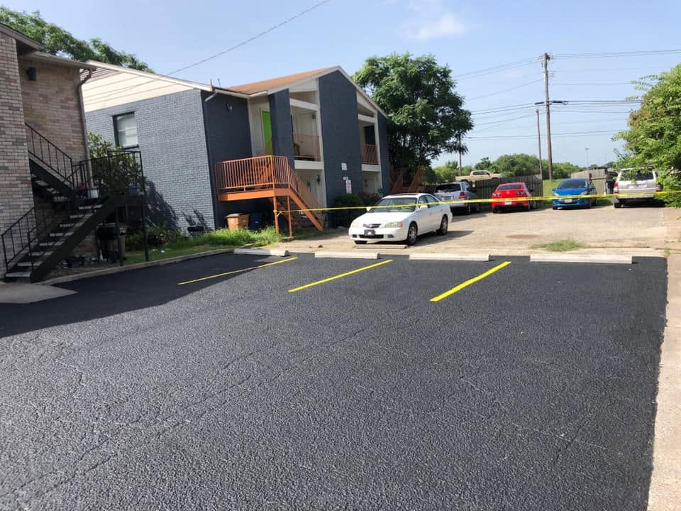 Freshly paved parking lot beside a commercial building