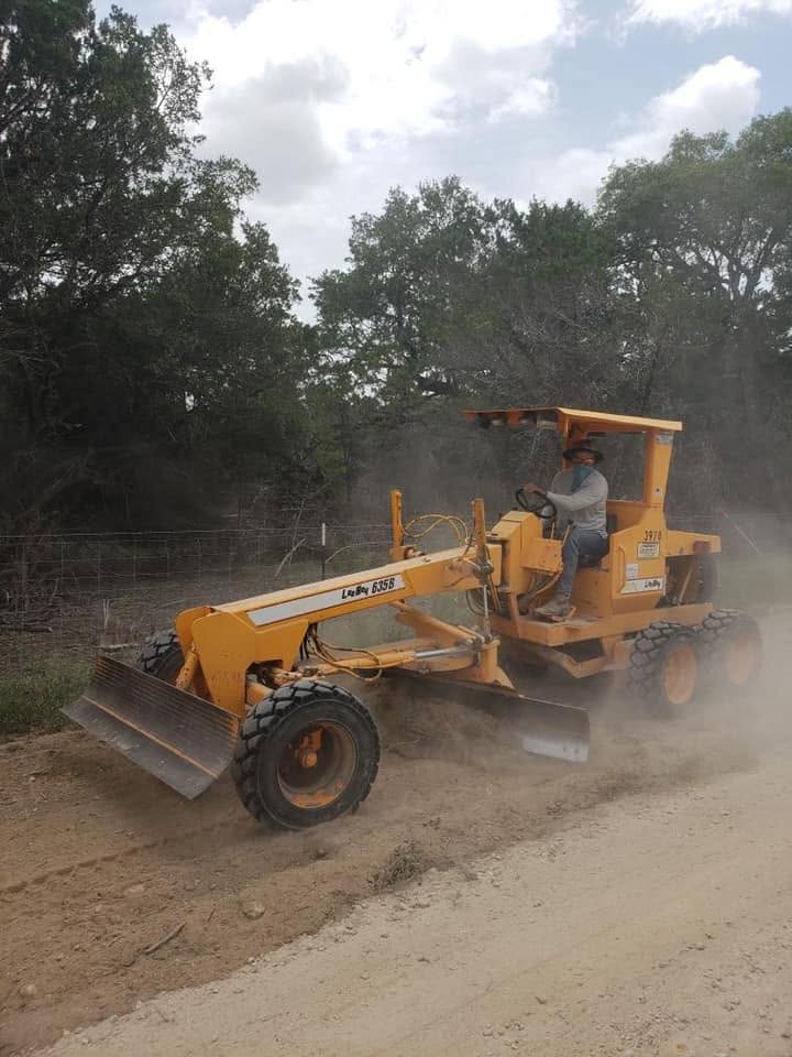 Road grader prepares a dusty surface for paving