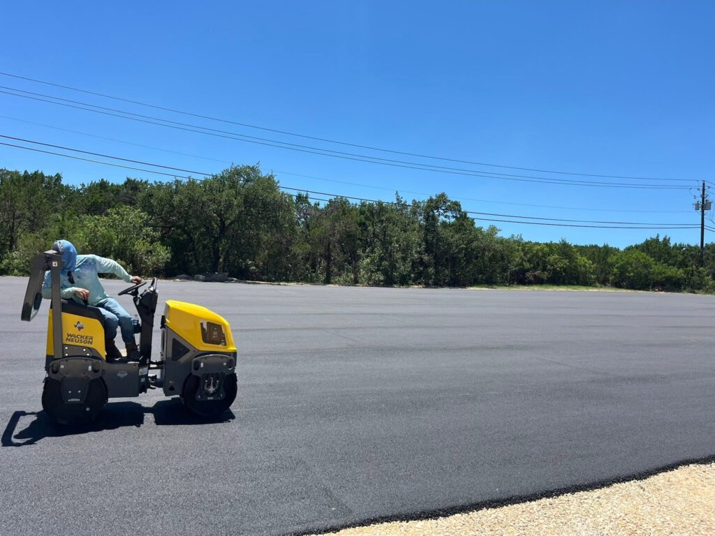 Road roller sits on a wide asphalt surface